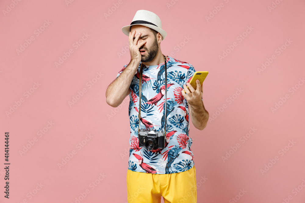 Displeased traveler tourist man in hat using mobile phone typing message put hand on face facepalm epic fail isolated on pink background. Passenger traveling on weekends. Air flight journey concept. Displeased traveler tourist man in hat using mobile phone typing message put hand on face facepalm epic fail isolated on pink background. Passenger traveling on weekends. Air flight journey concept.