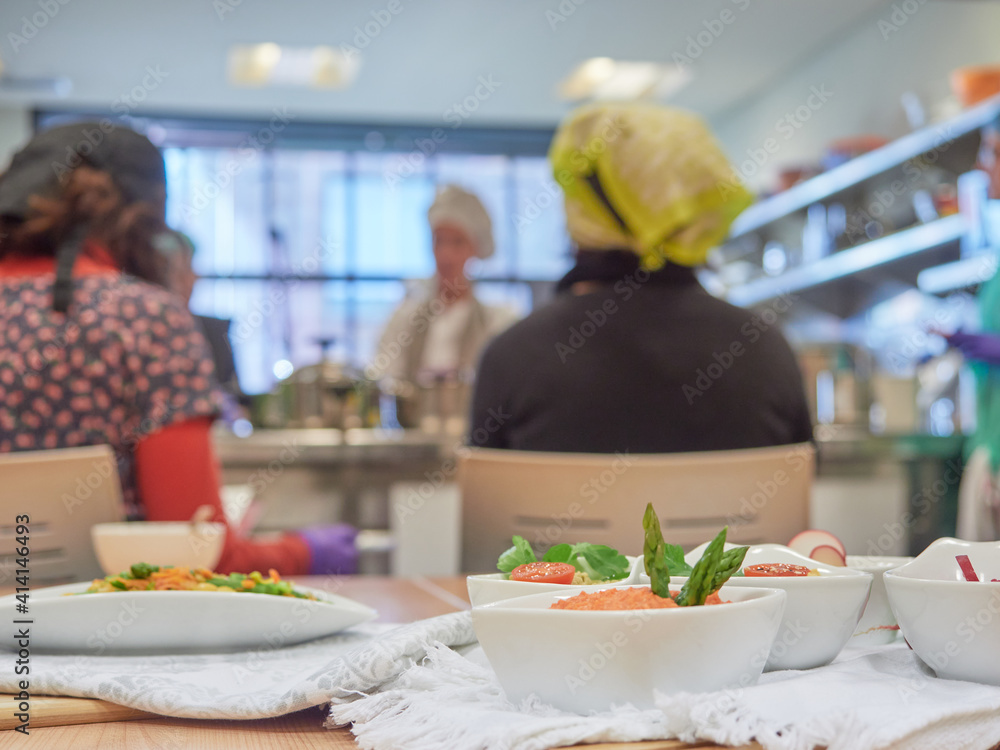 vegetarian cooking class, table with bowls of vegetable pâtés in the foreground and in the background the teacher and students