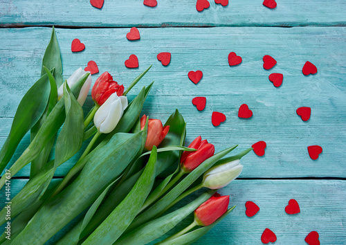 red and white tulips and wooden hearts on turuoise surface photo