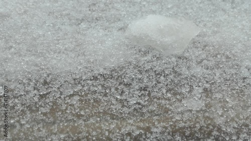 sleet pellets jumping over the snowy and iced ground