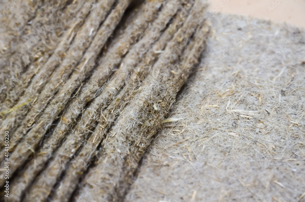 Selective focus on structure of linen seedling mats. Texture of substrate for growing microgreens. Organic substrate for sowing green seeds. Pile of folded linen fiber rugs.