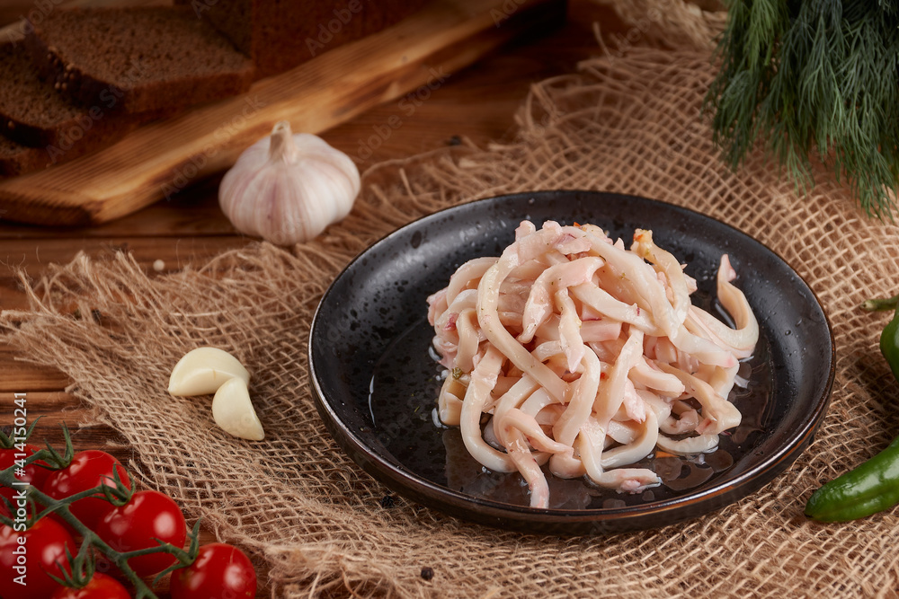 Seafood, squid in brine, delicious appetizer, wooden background Seafood, squid in brine, delicious appetizer, wooden background
