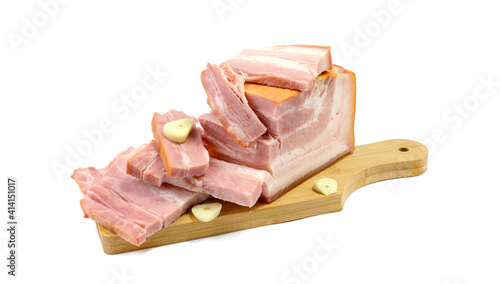 Smoked pork belly, bacon, ham on a wooden chopping board. White isolated background.