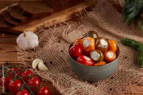 Antipasti Appetizer sweet cherry peppers stuffed with soft cheese feta. Wooden background