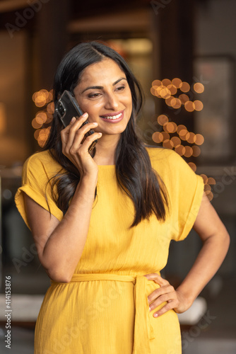 Beautiful Asian Indian woman talking / texting on mobile phone