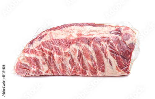 A piece of fresh pork meat in a vacuum package. Vacuum packaging raw fresh pork ribs isolated on a white background.