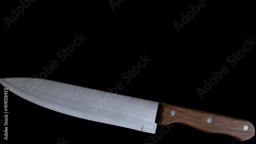 Kitchen Knife Spinning Around and Falling down on Black Background 