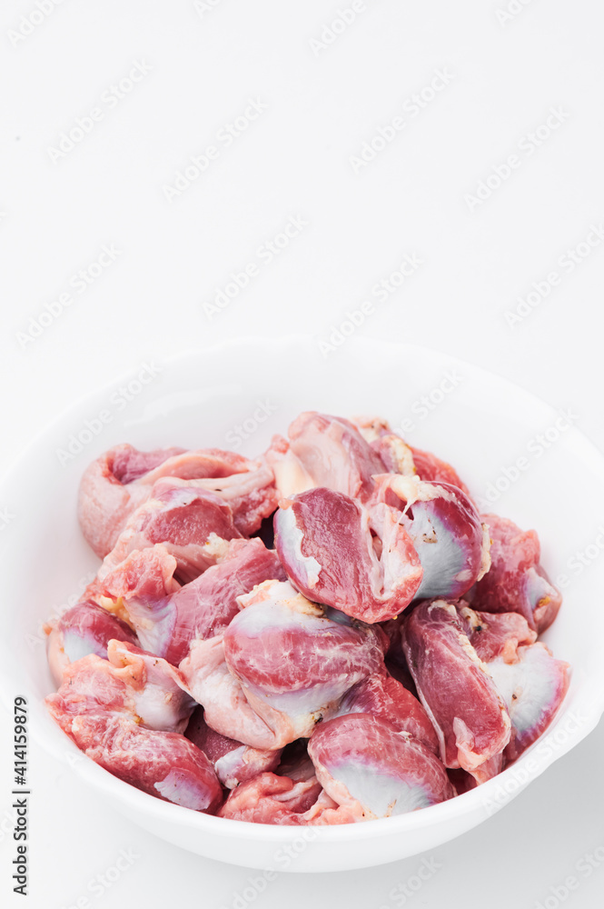 raw chicken thighs on a white plate on a white background. Photo for clipping