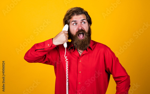 what a great surprise. handsome man has conversation. mature hipster with beard with retro phone. brutal caucasian guy speak on telephone. concept of communication. bearded man answer the call