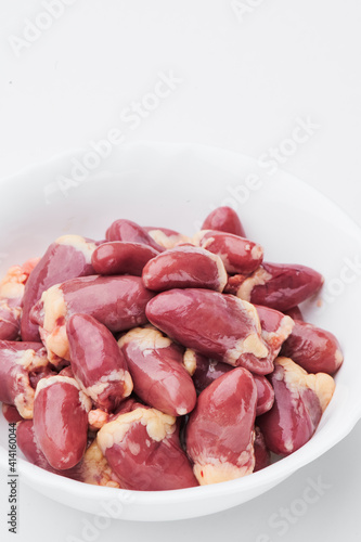 raw chicken hearts on a white plate on a white background. Photo for clipping