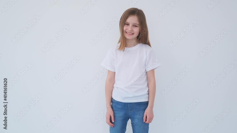 Cute little girl smilling in a white t-shirt and looking at camera Cute little girl smilling in a white t-shirt and looking at camera