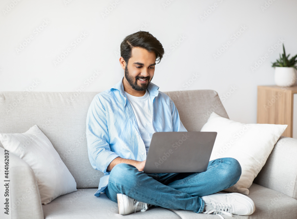 Distant Work. Happy Arab Freelancer Man Using Laptop Computer At Home Distant Work. Happy Arab Freelancer Man Using Laptop Computer At Home