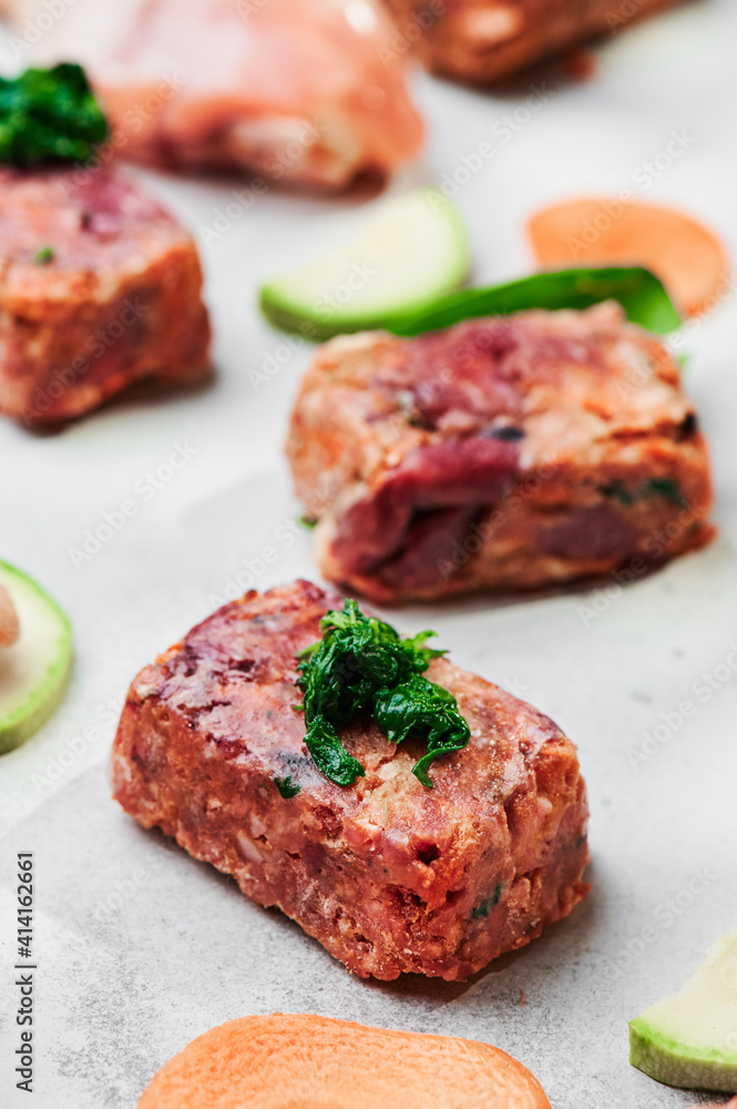 Composition with raw square cutlets on light background. Natural food for dogs. BARF dog diet Composition with raw square cutlets on light background. Natural food for dogs. BARF dog diet