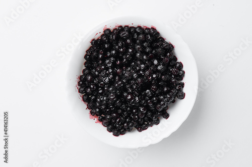 Bilberry on white plate isolated on white background. Top view. Free space for your text. Mockup