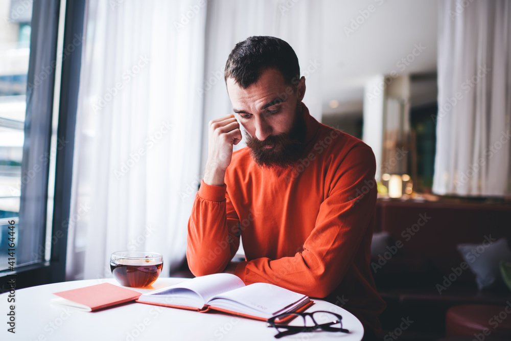 Focused man reading book in cafe Focused man reading book in cafe