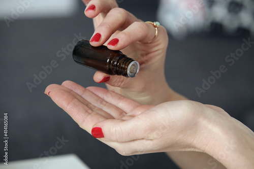 Female hands holding a bottle of essential oil