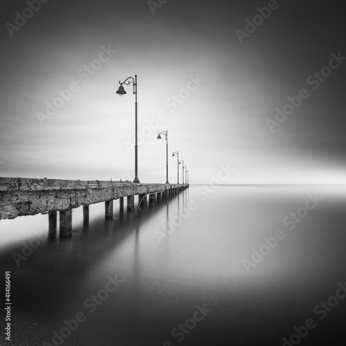 Obraz na płótnie Greyscale shot of lamps on a pier in the sea