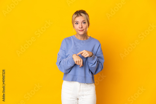 Young Russian woman isolated on yellow background making the gesture of being late © luismolinero