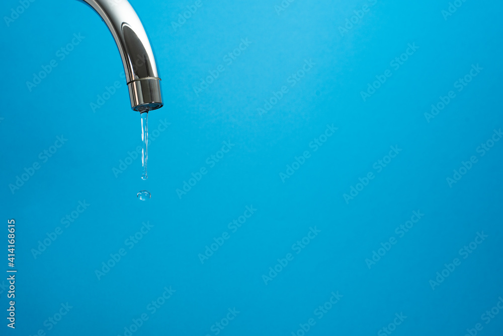 water coming out of a tap on blue background. Whith copyspace water coming out of a tap on blue background. Whith copyspace