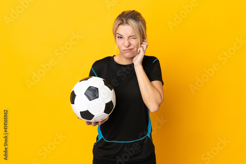 Fototapeta Naklejka Na Ścianę i Meble -  Young Russian football player woman isolated on yellow background frustrated and covering ears
