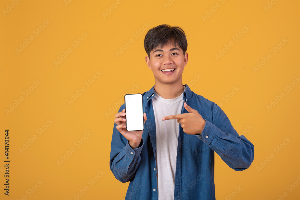 Asian man Pointing at the phone screen is blank on orange background Asian man Pointing at the phone screen is blank on orange background