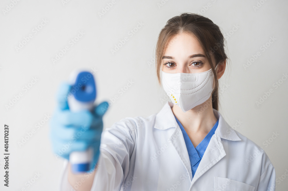 Selective focus hand of doctor in PPE using infrared thermometer gun to check temperature for coronavirus symptoms. Initial screening for covid19. Coronavirus and covid19 concept. Selective focus hand of doctor in PPE using infrared thermometer gun to check temperature for coronavirus symptoms. Initial screening for covid19. Coronavirus and covid19 concept.