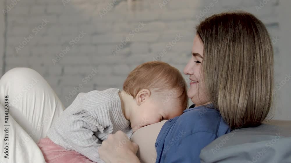 Beautiful cheerful baby girl with red hair smiling sitting astride on mommy Beautiful cheerful baby girl with red hair smiling sitting astride on mommy