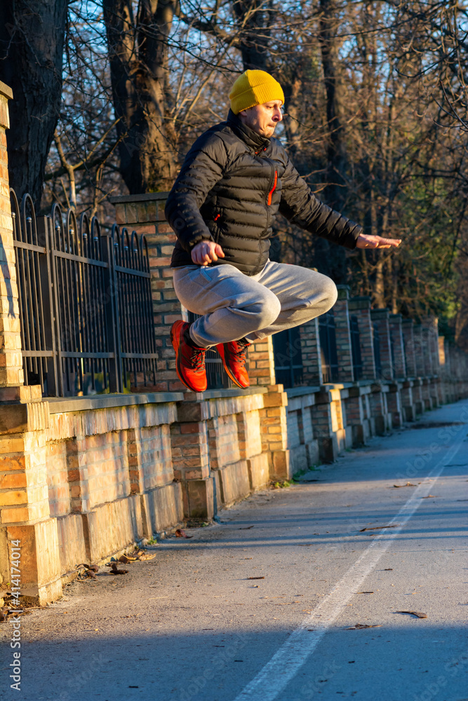 Full body photo athletic man jump high in green park wear winter sport outfit. Happy man jump after covid-19 Lockdown, quarantine. Full body photo athletic man jump high in green park wear winter sport outfit. Happy man jump after covid-19 Lockdown, quarantine.