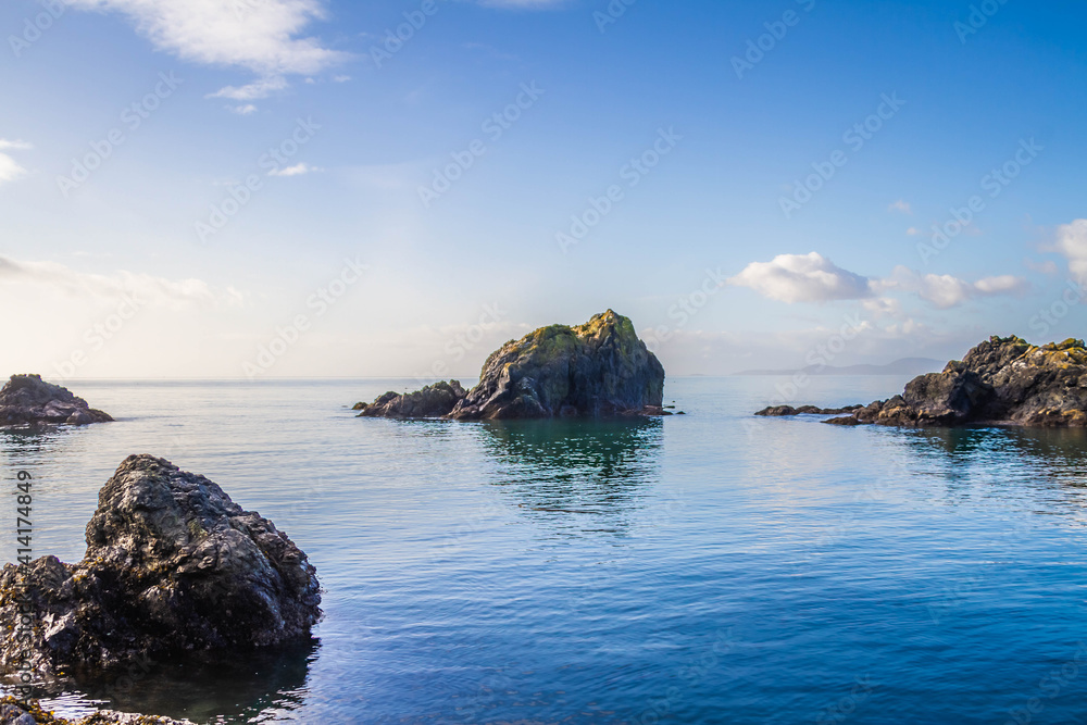 Rocks protruding from the surrounding blue ocean waters.