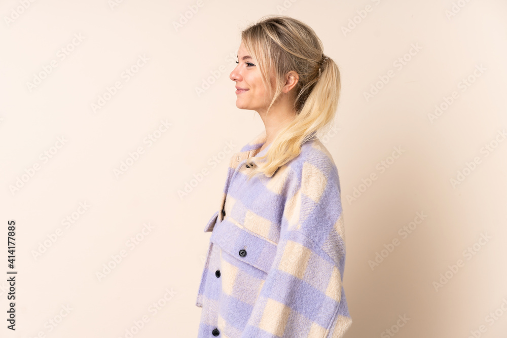 Blonde woman over isolated background looking side