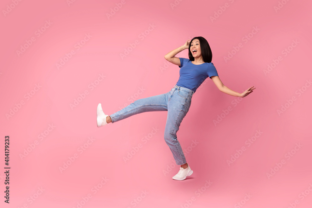 Happy young asian woman jumping at studio Happy young asian woman jumping at studio