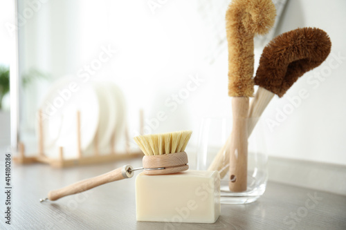 Cleaning brush and soap bar for dish washing on wooden table