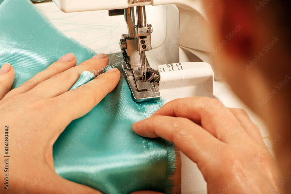 Professional tailor, fashion designer sitting and working at sewing studio. Needlework, tailoring,fashion, clothing repair and dressmaking concept. Sewing process, seamstress young woman working.