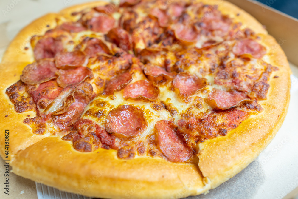 Tasty pepperoni pizza and cooking ingredients tomatoes basil on black concrete background. Top view of hot pepperoni pizza. Tasty pepperoni pizza and cooking ingredients tomatoes basil on black concrete background. Top view of hot pepperoni pizza.