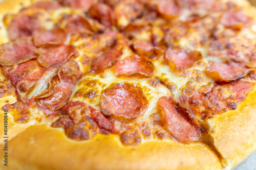 Tasty pepperoni pizza and cooking ingredients tomatoes basil on black concrete background. Top view of hot pepperoni pizza. Tasty pepperoni pizza and cooking ingredients tomatoes basil on black concrete background. Top view of hot pepperoni pizza.