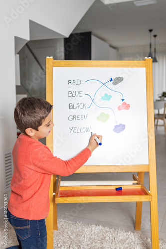 Quadro su tela Little boy learning english on a blackboard at home