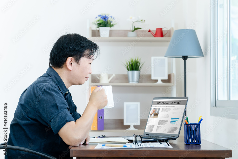 Businessman Checking Online News On Laptop with coffee in the morning