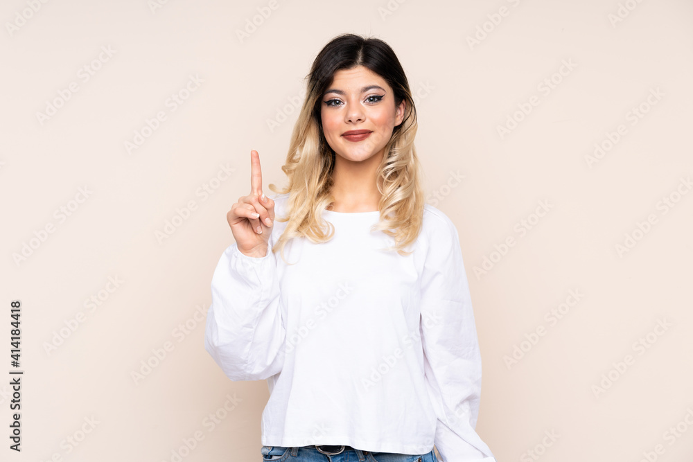 Teenager girl isolated on beige background pointing with the index finger a great idea Teenager girl isolated on beige background pointing with the index finger a great idea