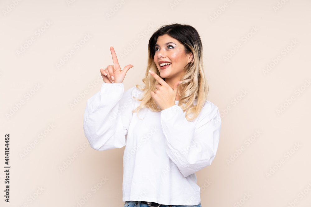 Teenager girl isolated on beige background pointing with the index finger a great idea Teenager girl isolated on beige background pointing with the index finger a great idea