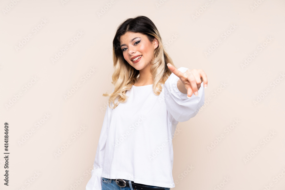 Teenager girl isolated on beige background giving a thumbs up gesture Teenager girl isolated on beige background giving a thumbs up gesture