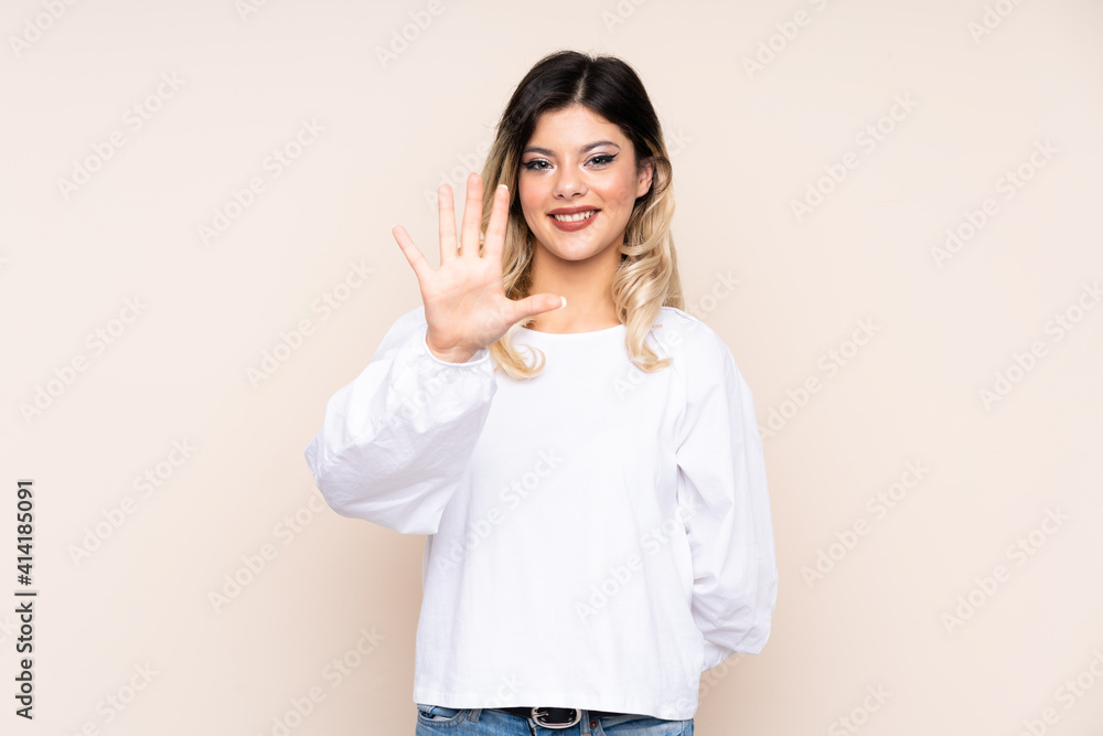 Teenager girl isolated on beige background counting five with fingers Teenager girl isolated on beige background counting five with fingers