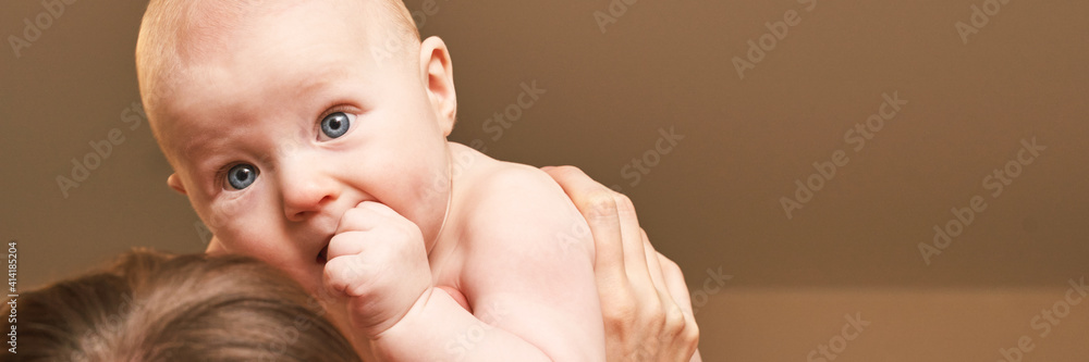 Cute small boy at mother hands. Childhood concept. Serious child. Calm emotion. Copyspace. Stay home. Blue eyes. Horizontal banner. Family care Cute small boy at mother hands. Childhood concept. Serious child. Calm emotion. Copyspace. Stay home. Blue eyes. Horizontal banner. Family care
