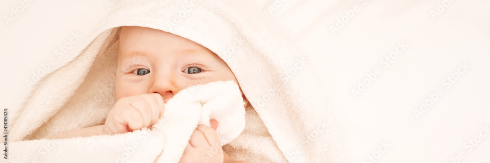 Cute small boy lying at bed. Childhood bath concept. Light background. Little child. Serious emotion. Copyspace. Stay home. Towel mockup. Hide from mom. Horizontal banner Cute small boy lying at bed. Childhood bath concept. Light background. Little child. Serious emotion. Copyspace. Stay home. Towel mockup. Hide from mom. Horizontal banner