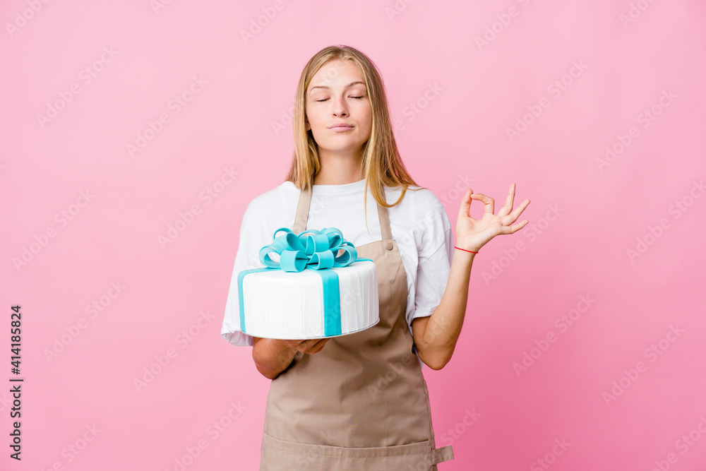 Young russian baker woman holding a delicious cake relaxes after hard working day, she is performing yoga. Young russian baker woman holding a delicious cake relaxes after hard working day, she is performing yoga.