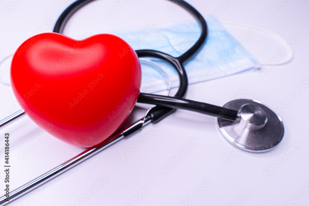 Stethoscope and red heart on wooden table. Cardiology concept Stethoscope and red heart on wooden table. Cardiology concept