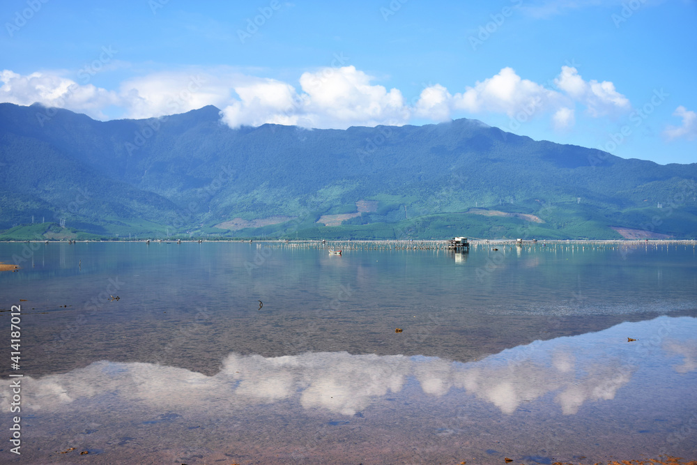 Hoi An, Vietnam: Perfect water reflection of mountains at a large shallow lake and fishing village just north of Hoi An Imperial City Hoi An, Vietnam: Perfect water reflection of mountains at a large shallow lake and fishing village just north of Hoi An Imperial City