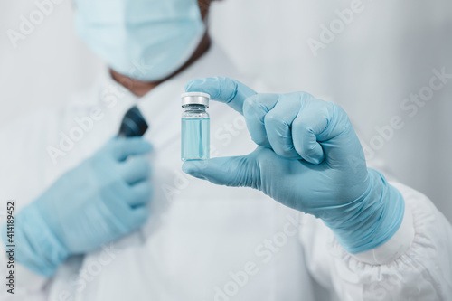 doctor with gloves. Coronavirus vaccine COVID-19 Coronavirus vaccine in a glass bottle.