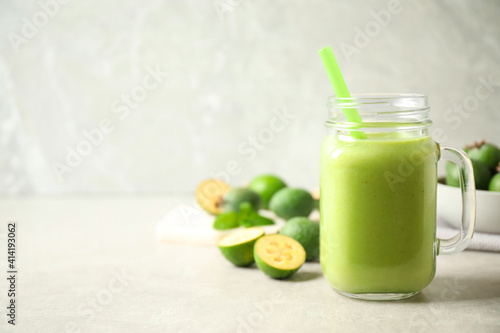Fresh feijoa smoothie in mason jar on light table, closeup. Space for text
