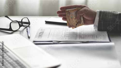 Corruption concept, businessman holding money in hand and give bribe for signing contract political favours