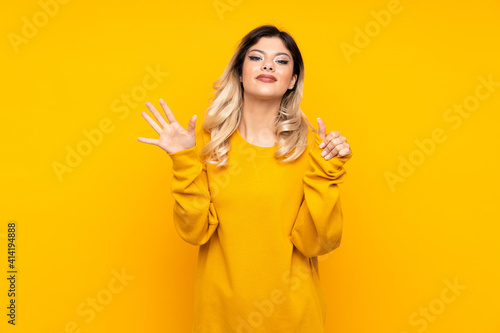 Teenager girl isolated on yellow background counting six with fingers